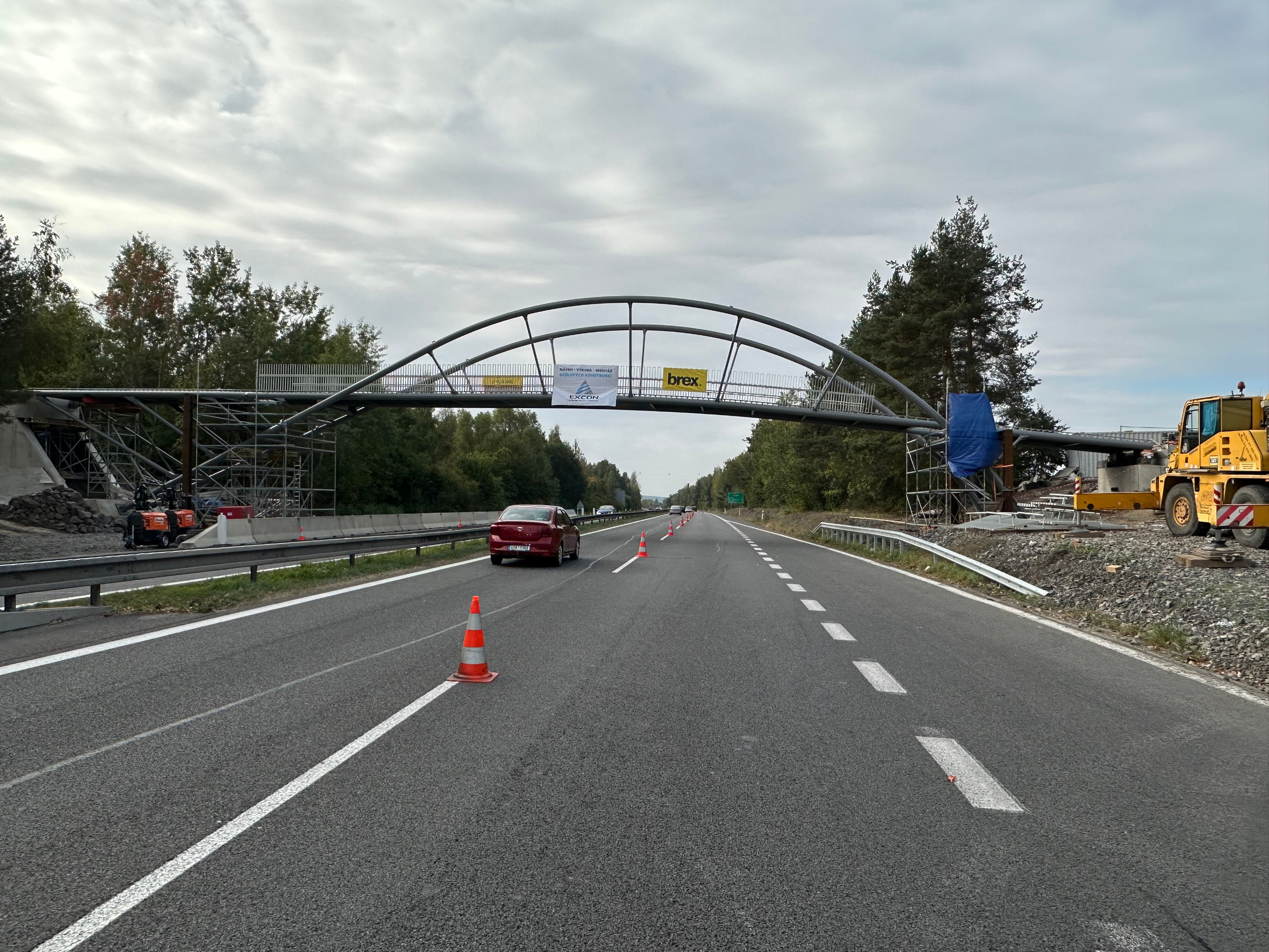 Usazení ocelové konstrukce lávky pro pěší a cyklisty na dálnici D10 v blízkosti sjezdu na Mnichovo Hradiště
